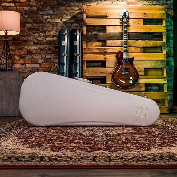 white molded guitar case with black cases and electric guitar in background
