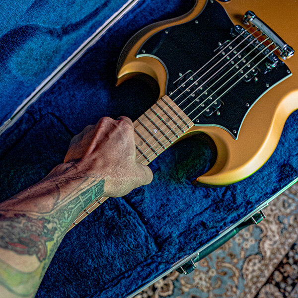 Vectra® 3.2 Form-Fit SG® Style Pro-Form® USA Molded Guitar Case man with tattoo holding the fretboard of the guitar in the guitar case